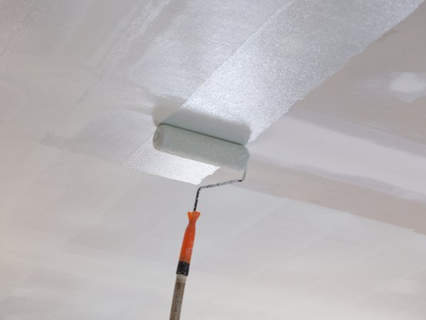 Applying paint on a ceiling with a roller