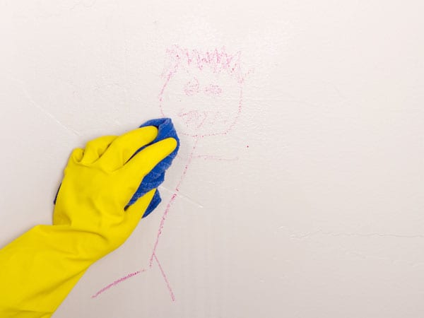 Cleaning kid drawing off a painted wall