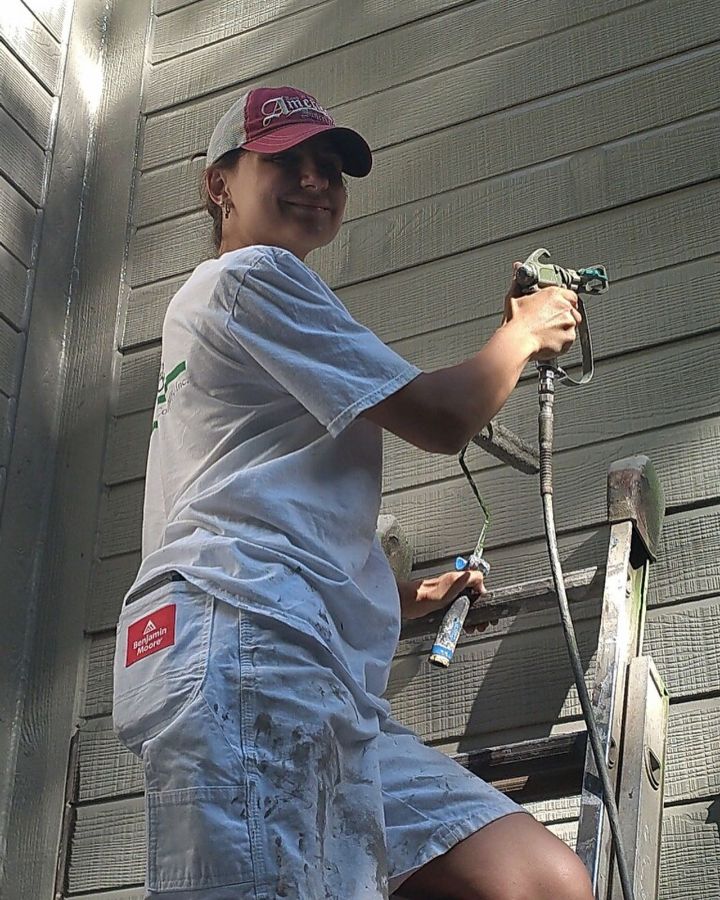 Paint spraying a house exterior