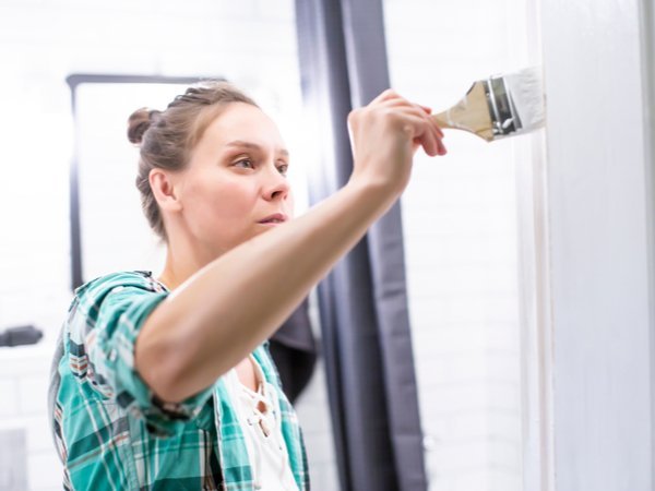 Woman painting a bathroom door