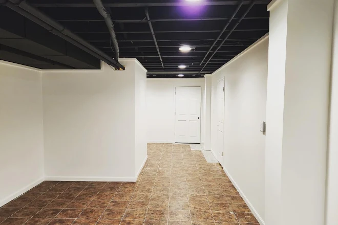 A basement with white walls and a black ceiling