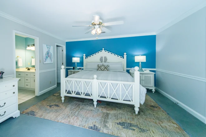 A bedroom with a blue accent wall behind the bed.