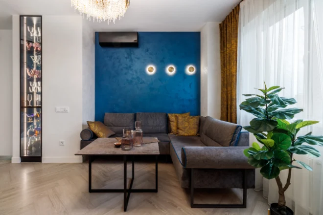 A dark blue feature wall in this living room contrasts with the other white walls
