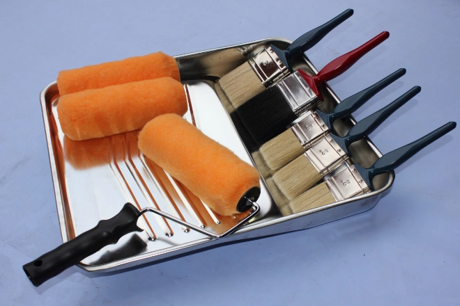 A decorators paint tray with rollers and brushes