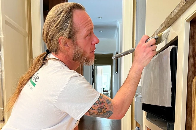 A professional painter works his craft in a kitchen