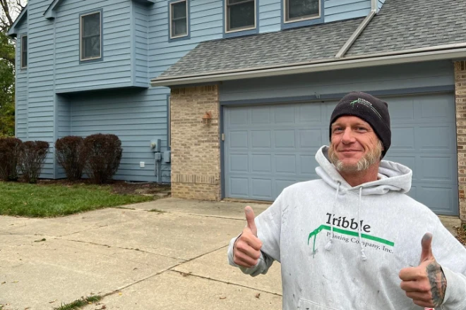 A-professional-Tribble-painter-poses-in-front-of-a-new-paint-house-exterior.
