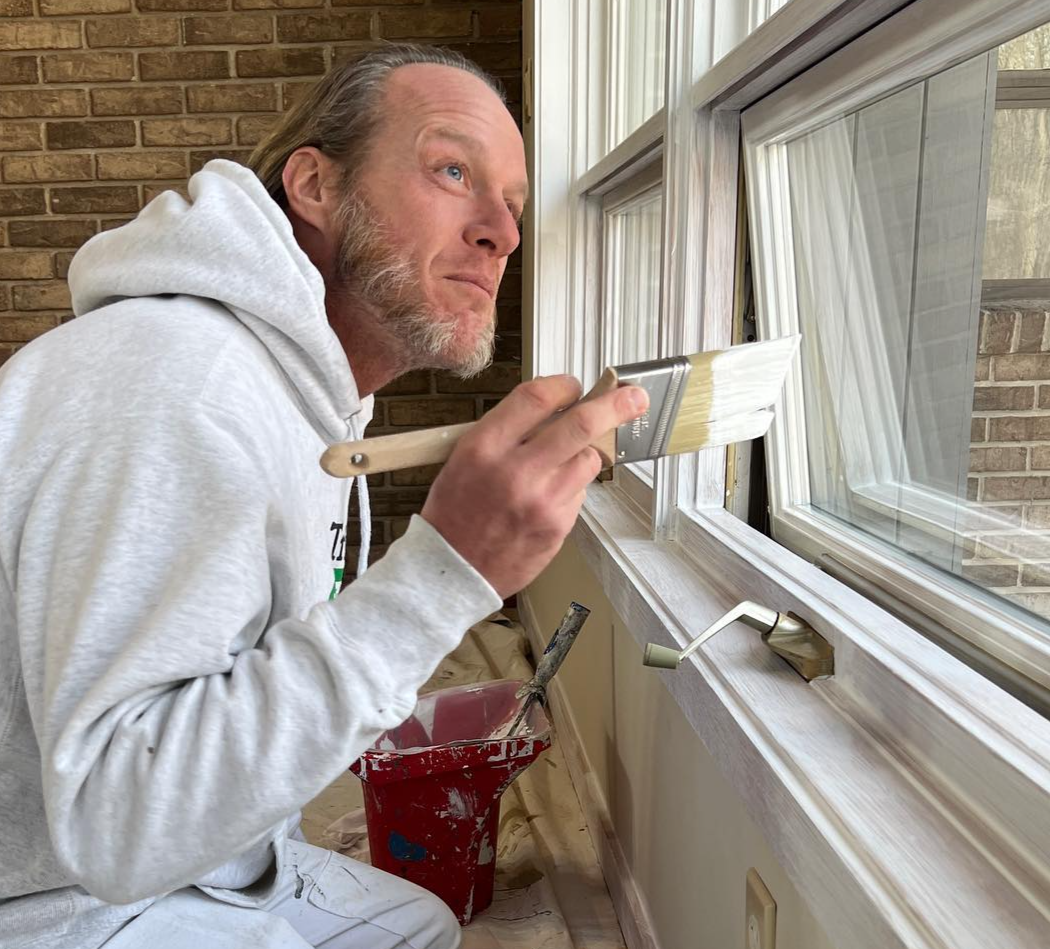 A Tribble Painting employee applies paint to an unpainted window sill