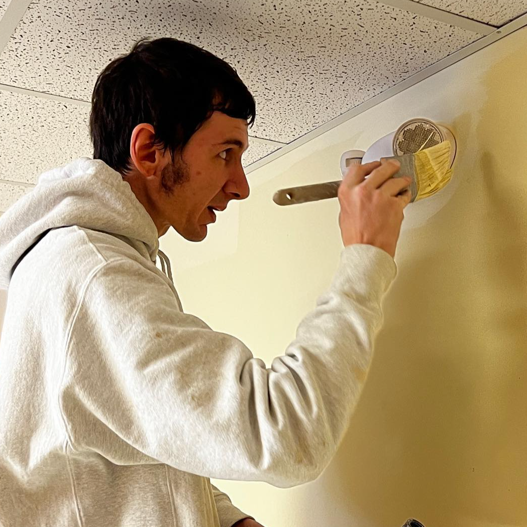 A Tribble Painting employee carefully applies paint to a wall