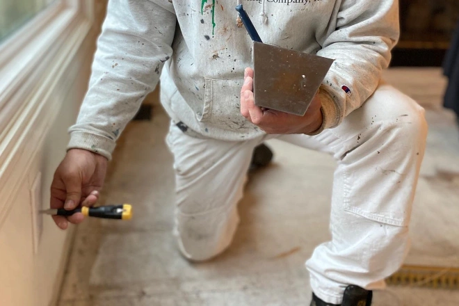 A Tribble Painting employee reattaches an outlet cover after a paint job