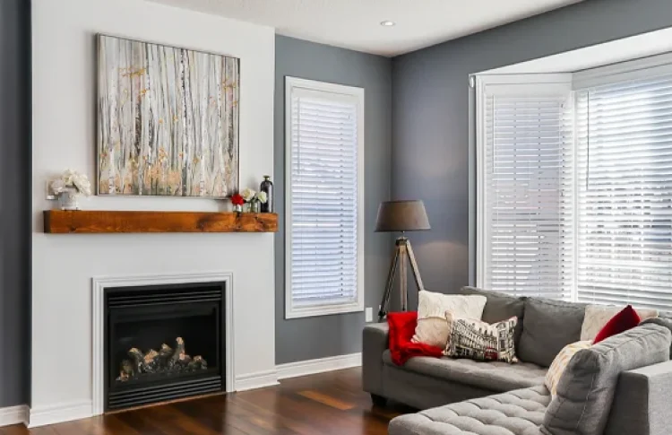 Interior of a living room with grey walls and white fireplace