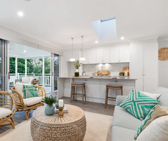 Living room and kitchen painted white with color accents and a skylight