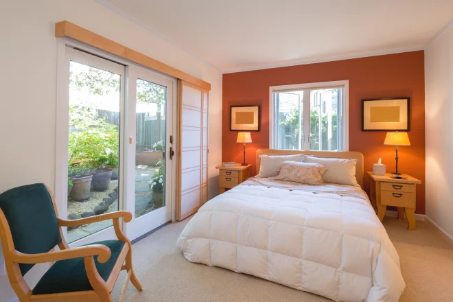 Interior modern bedroom with orange accent wall and french doors