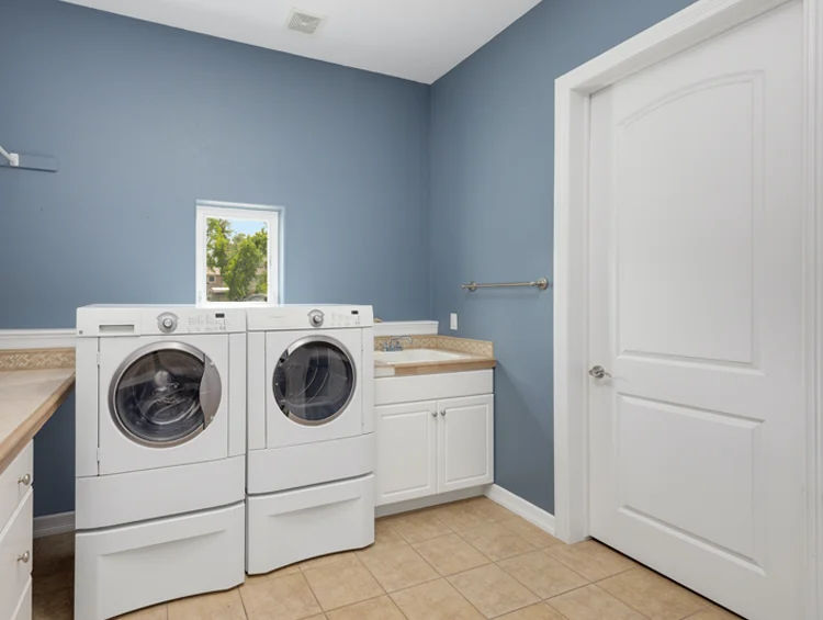 Laundry room painted blue with white door