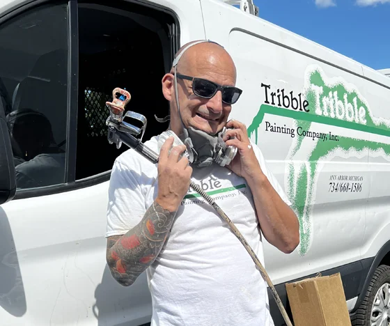 Tribble painter posing with supplies in front of the truck