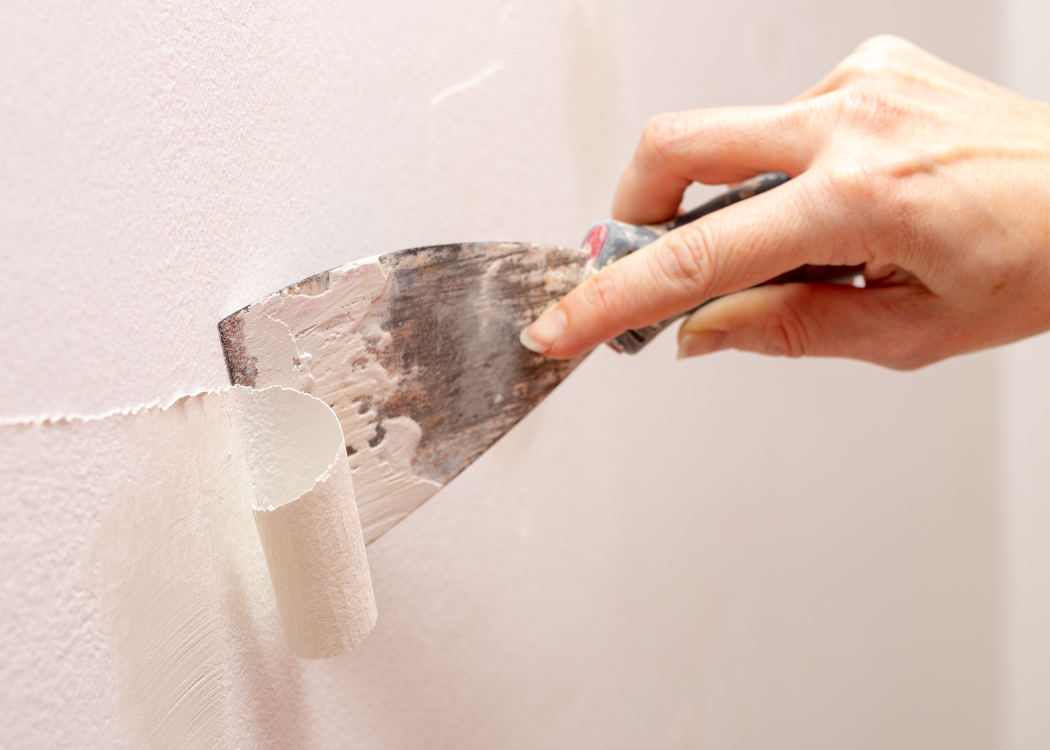 Stripping old paint from the wall. Renovation and painting of walls in the apartment.