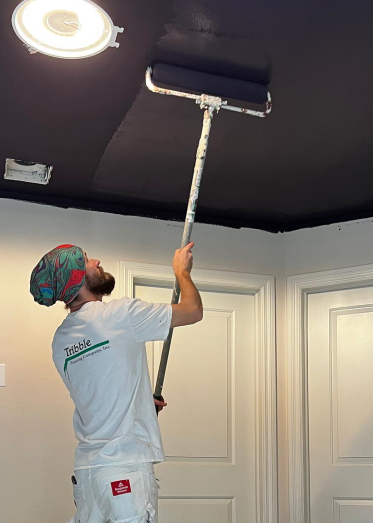 Tribble Painting employee applies paint to a celiling.